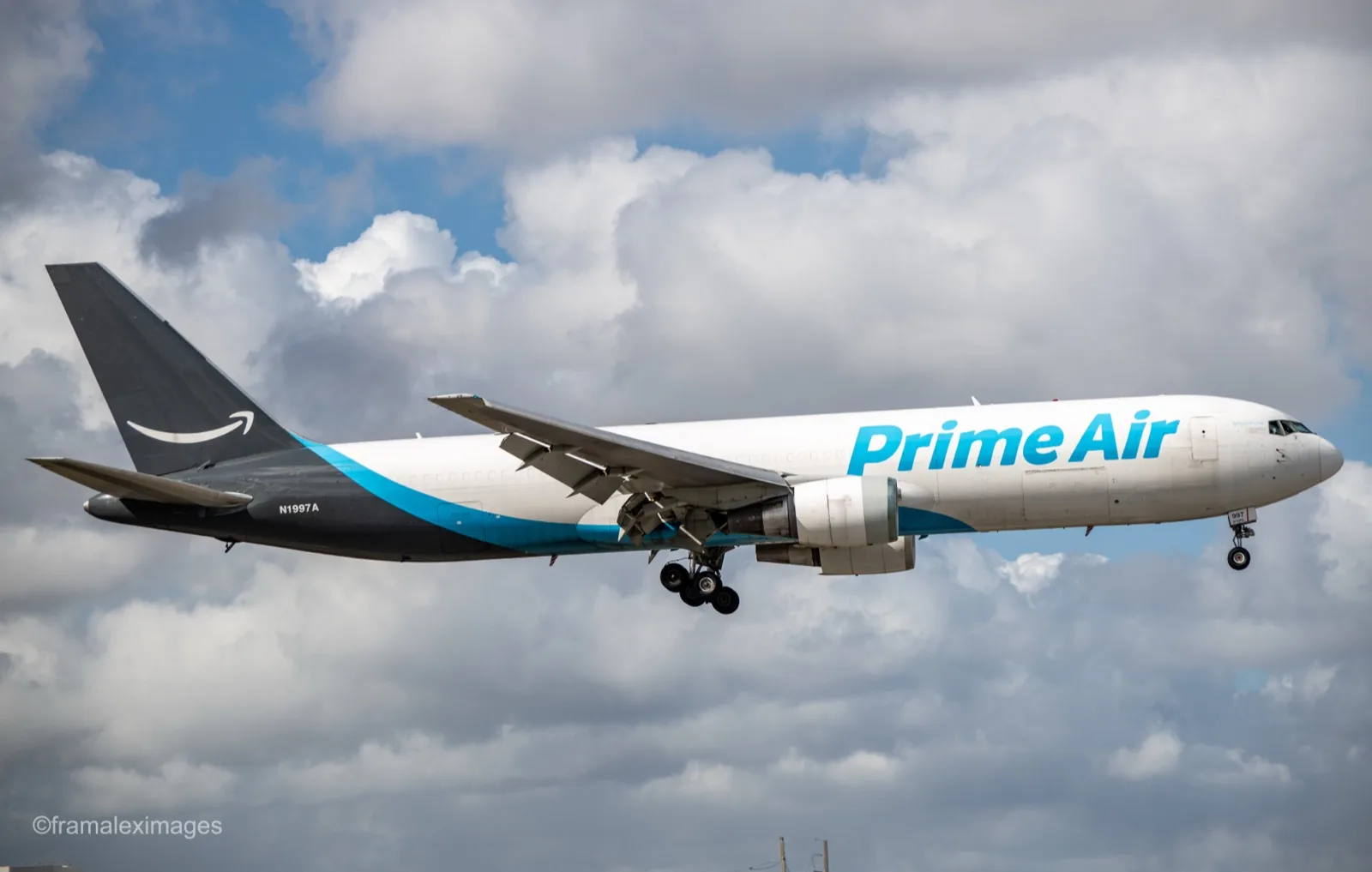 Amazon Prime Air Boeing 767 N1997A on short final into Miami, gear down, against a sky full of cumulus